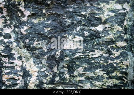 Detailed close-up of a granite rock surface showcasing intricate textures and natural patterns in shades of black, gray, and pink Stock Photo
