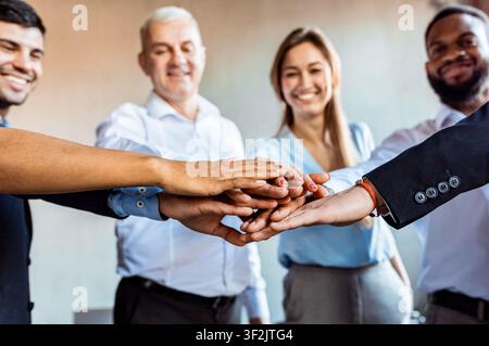 Cheerful Business People Holding Hands Standing In Circle In Office Stock Photo