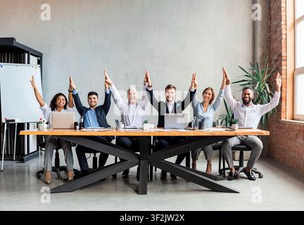 Coworkers Giving High-Five Celebrating Business Success Sitting In Modern Office Stock Photo