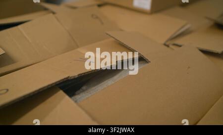 Large cardboard boxes in stock before shipping. Cardboard boxes with frozen fish. Fish production. Big fish packs fish in a cardboard box. Stock Photo