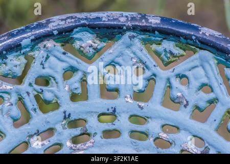 The upper back of a weathered metallic garden chair, in a farm in the eastern Andean mountains of central Colombia, near the Iguaque natural reserve. Stock Photo