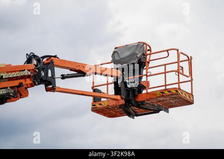 Industrial boom lift cage with safety metal railings and control panel cover symbolizing heavy duty lifting gear and engineering technology Stock Photo