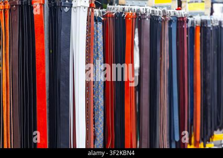 Full frame texture of colorful genuine leather and braided waist belts hanging in rows at a fashion market stall Stock Photo
