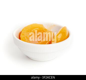 Canned Peaches in Bowl Isolated, Apricot Halves in Syrup, Yellow Fruit Dessert, Tinned Nectarine Compote, Orange Peeled Peache Slices on White Backgro Stock Photo