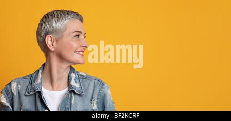 Nice Promo. Smiling Mature Lady Looking With Interest At Copy Space Stock Photo