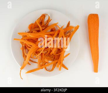 Carrot skins, vegetable peelings isolated on a white background as a symbol of ecological waste, bio garbage Stock Photo