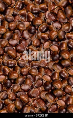 Edible sweet whole chestnuts pattern, textured background. Raw healthy delicious chestnut, autumn and christmas european food top view Stock Photo