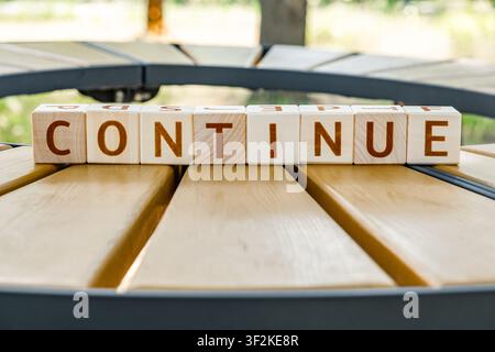 motivational word Continue made of letters on wooden cubes Stock Photo