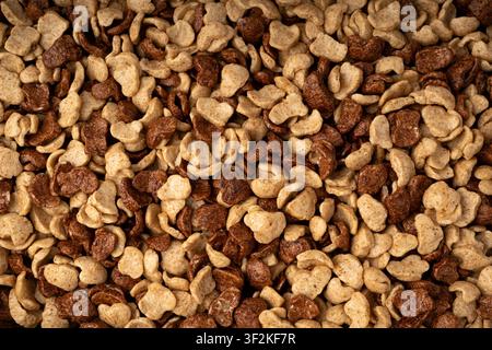 Chocolate cereal flakes texture background, rice crispy breakfast pattern. Corn and choco cornflakes wallpaper, breakfast caramel cereal pops mockup w Stock Photo