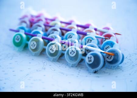 Angled view of a set of paints with brushes lying on jars, with an emphasis on the right side of the Stock Photo