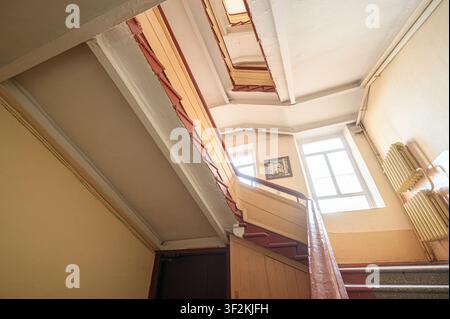 stairwell from a low angle, emphasizing its upward spiral and natural light from windows Stock Photo