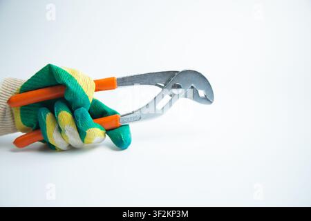 A hand in a protective glove holds the adjustable wrench horizontally, showing the working tool on a Stock Photo