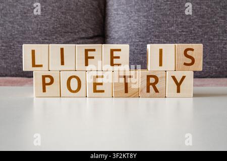 motivational phrase Life Is Poetry made of letters on wooden cubes Stock Photo