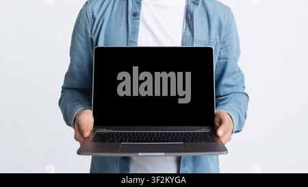 Empty screen laptop screen in hands of man Stock Photo