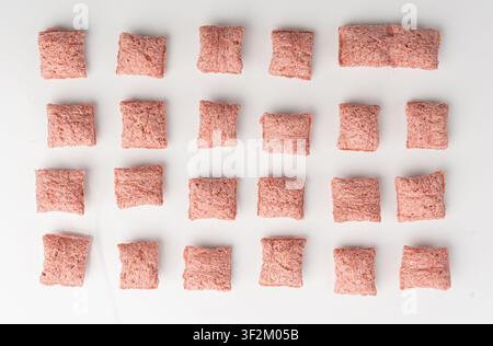 Fruit pillows, strawberry corn pads for breakfast isolated. Pink crispy corn flakes with milk and berry filling on white background Stock Photo