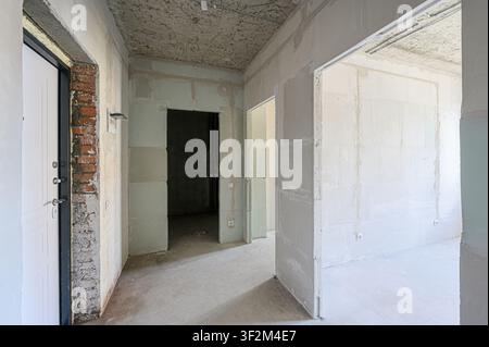 Interior of a building under construction, featuring exposed brick, unfinished walls, and open doorways Stock Photo