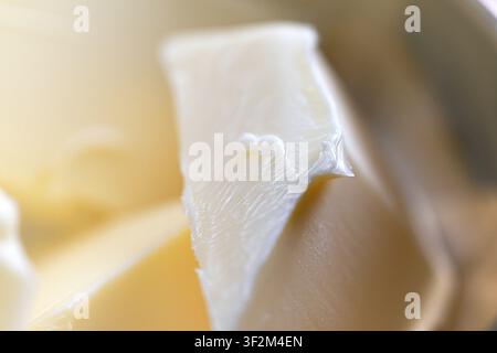 Close-up of fresh butter in a metal bowl with soft natural light. Dairy ingredient for baking, cooking and breakfast Stock Photo
