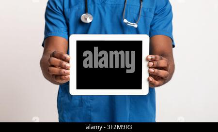 Empty digital tablet screen in black doctor hands Stock Photo