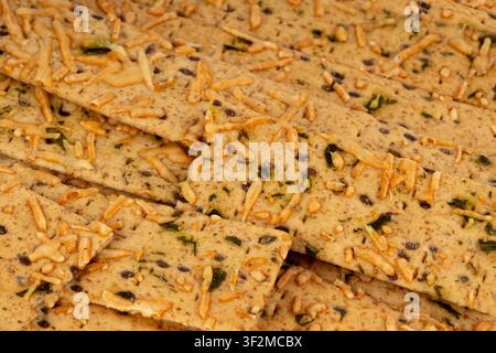 Crunchy gluten free crispbread pattern with various seeds and cheese. Whole grain wheat crisp bread or cracker with sesame macro textured background Stock Photo