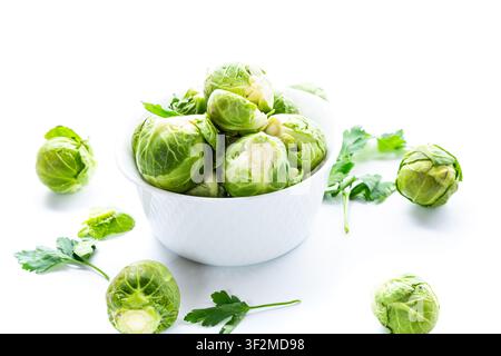 fresh brussels sprouts in white bowl on clean background. Stock Photo