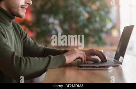 Cropped of male freelancer typing on laptop at cafe Stock Photo