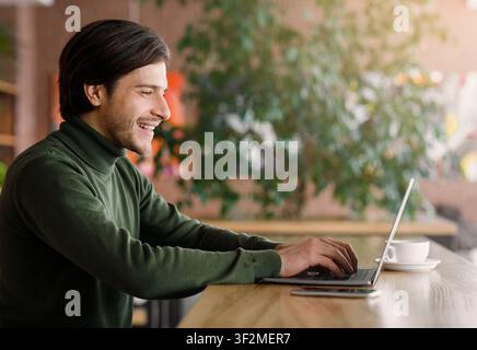 Successful web-designer working at cafe, using laptop Stock Photo