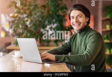 Cheerful programmer working at cafe, enjoying his job Stock Photo