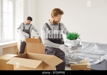 Professional workers of moving service packing cardboard boxes. Moving day concept Stock Photo