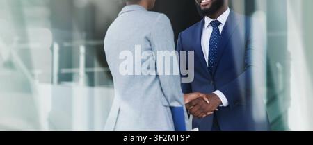 Business Meeting With Happy Black Male And Female Professionals Shaking Hands In Office Stock Photo