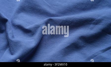 A close-up shot of soft wrinkled blue jersey fabric. Stock Photo