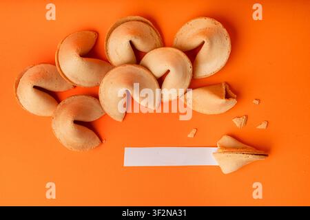 Fortune cookie set. Lucky Chinese biscuit with prediction paper, asian surprise sweets collection on orange background Stock Photo