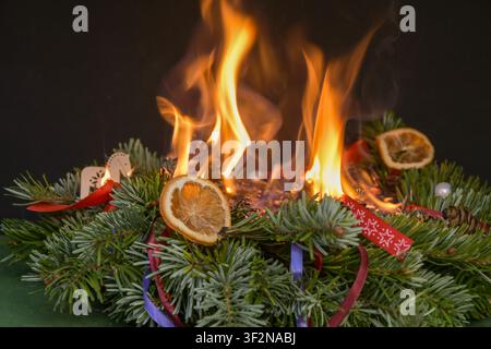 Christmas wreath completely engulfed in open flames after festive decorations caught fire indoors Stock Photo