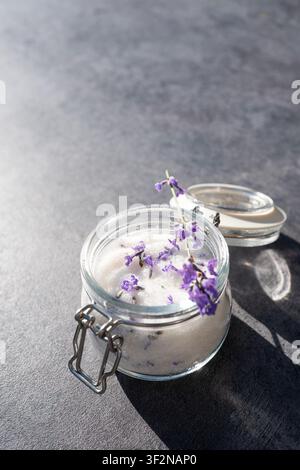 Lavender sugar in glass jar with fresh lavender on gray background Stock Photo