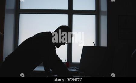Individual Seated At Windowed Workstation Engrossed In Important Phone Call With Serious Intent. Media Stock Photo