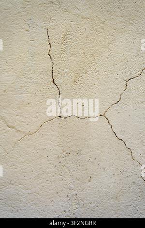 Weathered Beige Plaster Wall Texture with Natural Crack Pattern and Distressed Surface Background. Stock Photo