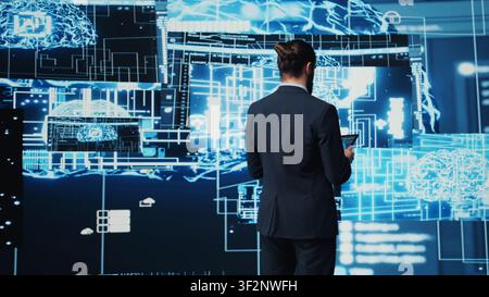 IT specialist interacting with digital AI neural networks for deep learning and algorithmic thinking, ensuring smart tech innovation and future development strategy with science. Camera B. Stock Photo