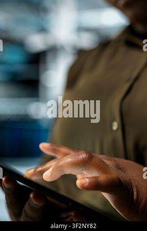 Close up of data center technician optimizing network infrastructure, planning capacity. IT professional managing server farm resources for improved reliability and uptime Stock Photo