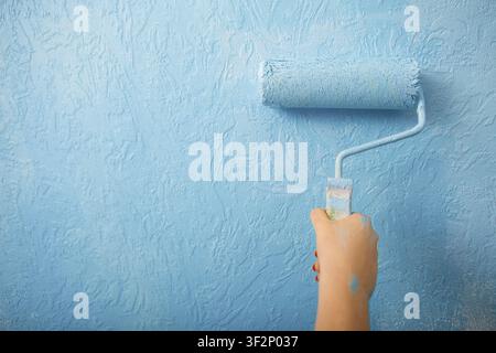 New project for home design. Female hand paints wall Stock Photo