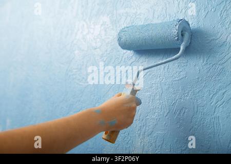 Paint rollers on plaster textured background, close up Stock Photo