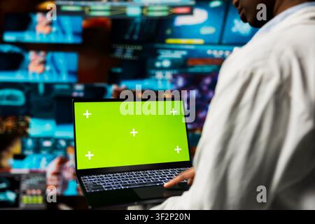 Close up of researcher looking at CT scans data on green screen mockup laptop. Scientist analyzing neurology research on chroma key notebook, diagnosing failing human organs Stock Photo
