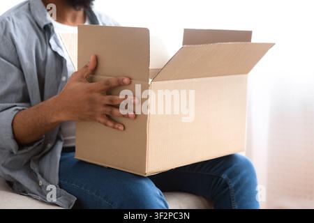 Afro american man holding big box with online purchases Stock Photo