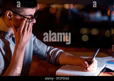Man Touching Aching Eye Working In Dark Office Room Stock Photo