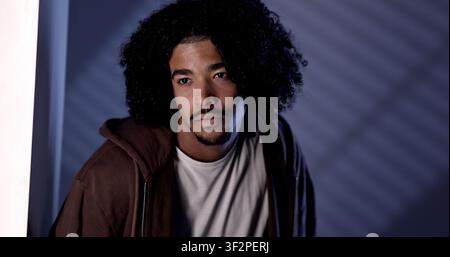 Young man wearing a hoodie and looking contemplative, experiencing sadness or melancholia Stock Photo