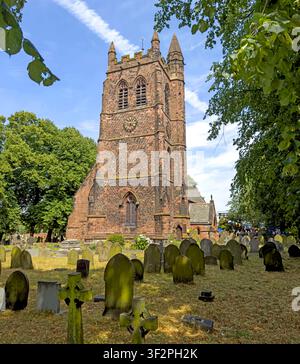 St Thomas Church and its historic graveyard on London Road, Stockton Heath, Warrington, Cheshire, beneath a bright summer sky. Stock Photo