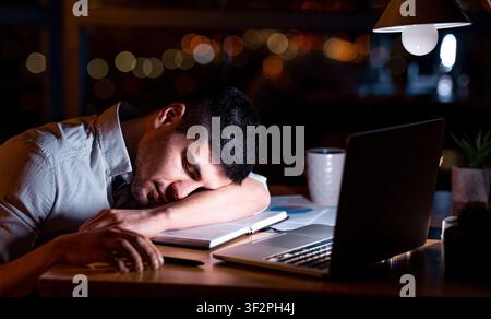 Businessman Sleeping At Laptop Sitting In Office Late At Night Stock Photo