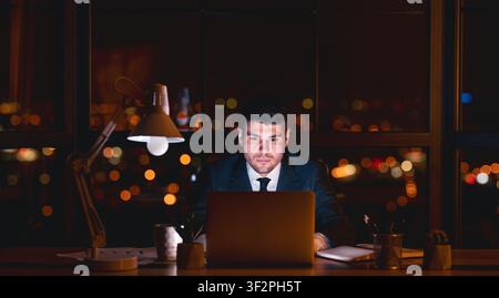 Entrepreneur Guy Working On Laptop Overnight In Modern Office, Panorama Stock Photo
