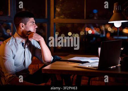 Guy Sitting At Work Thinking On Business Project In Office Stock Photo