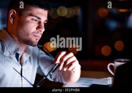 Businessman Thinking Holding Glasses Working In Office At Night Stock Photo