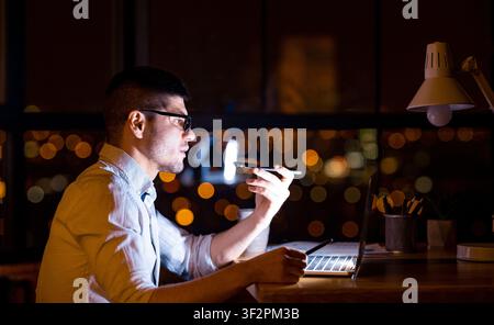 Serious Entrepreneur Using Loudspeaker Talking On Cellphone In Modern Office Stock Photo