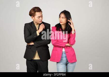 portrait of pensive asian Indonesian business man and woman with thinking gesture on isolated background Stock Photo